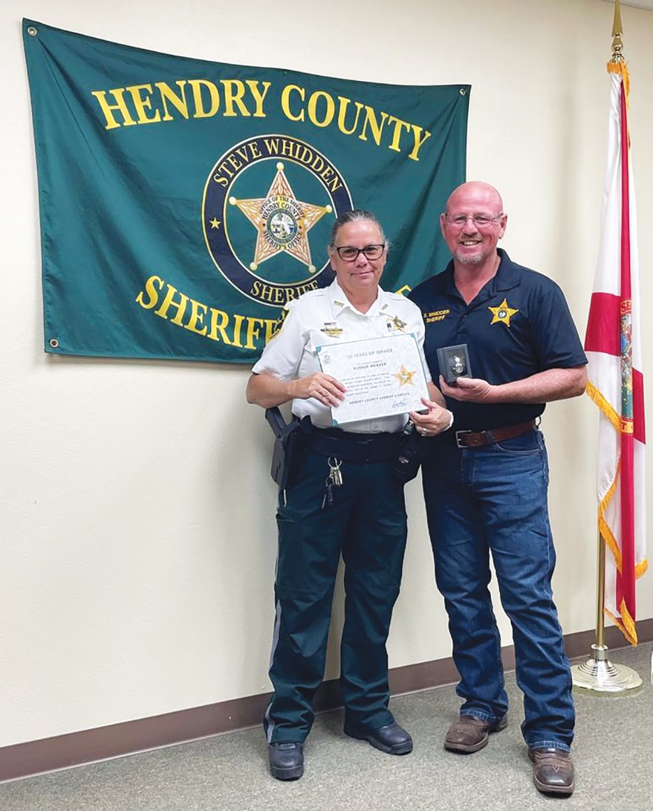 Lt. Bonnie Weaver, left, was recognized by Hendry County Sheriff's Office for 20 years of service. Presenting a plaque to her is Sheriff Steven Whidden.